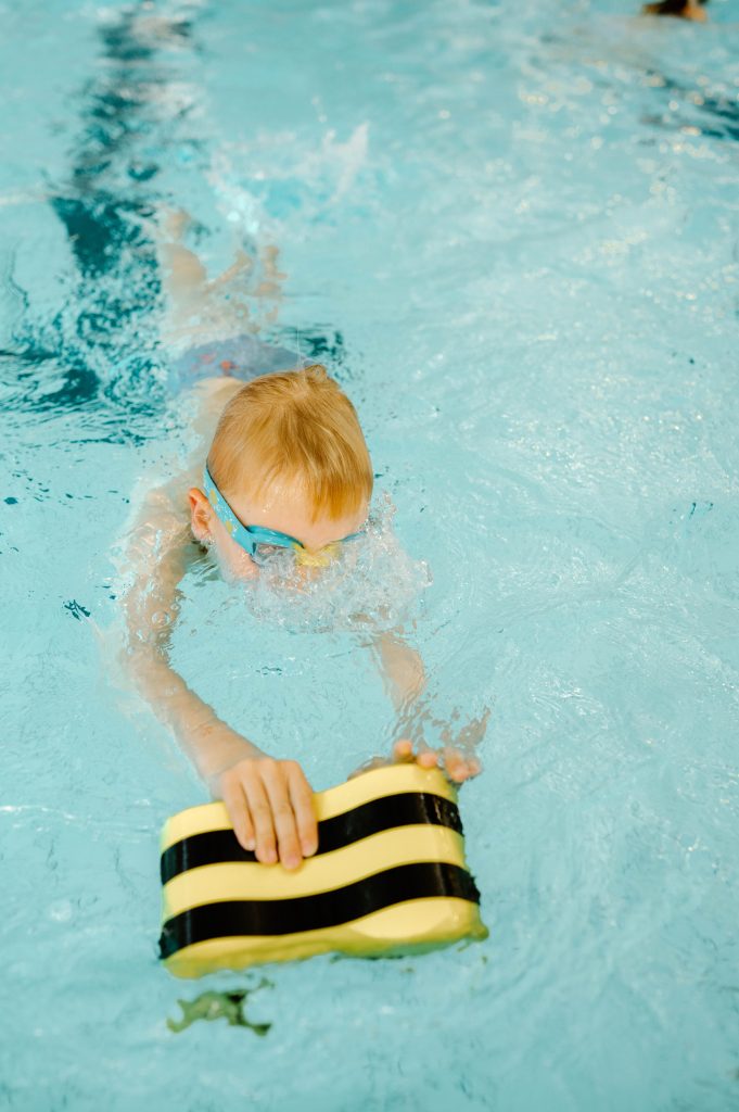 Kind zwemt met kickboard tijdens privézwemles